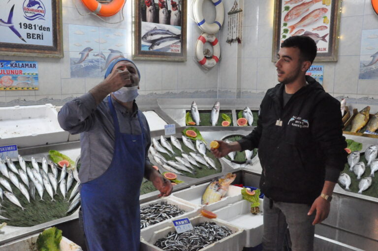 Çiğ balığın üzerine limonu sıkıp yiyor