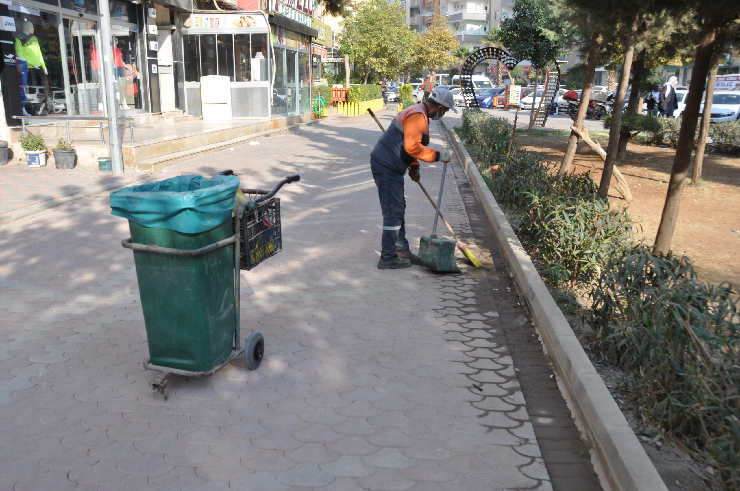 Sokakları ritim tutturarak temizliyor